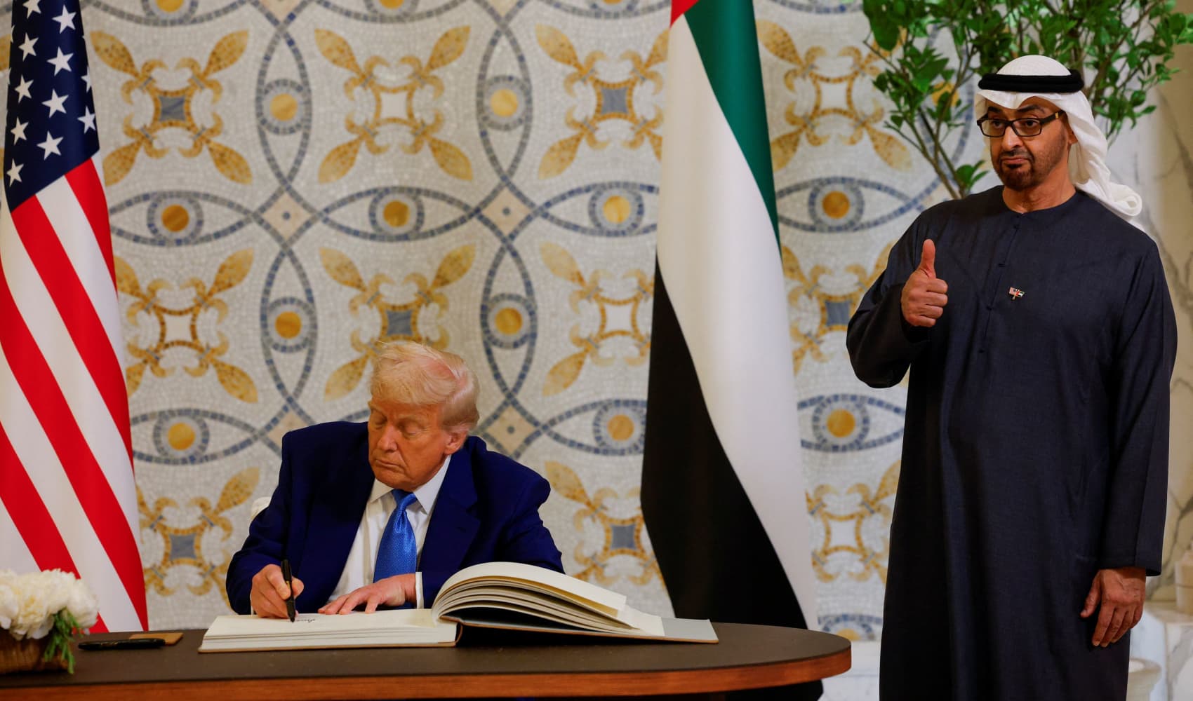 U.S. President Donald Trump signs a guest book next to United Arab Emirates President Sheikh Mohamed bin Zayed Al Nahyan, at Qasr Al Watan, in Abu Dhabi, United Arab Emirates, May 15, 2025.